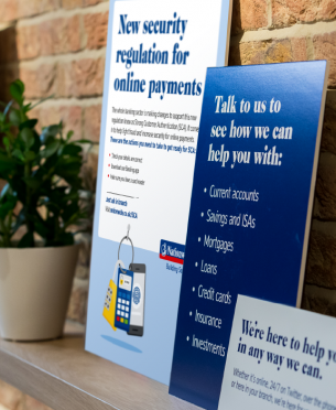 Three informational posters on a shelf. First poster: 