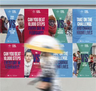 Outdoor display of posters promoting the 'Future Steps' challenge, with various designs featuring the text 'Can you beat 10,000 steps every day in February?'